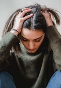 A girl in stress wearing green sweater