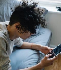 A guy searching for mental health resources on a tablet