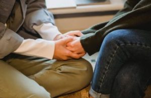 A person holding hands of another person in therapy