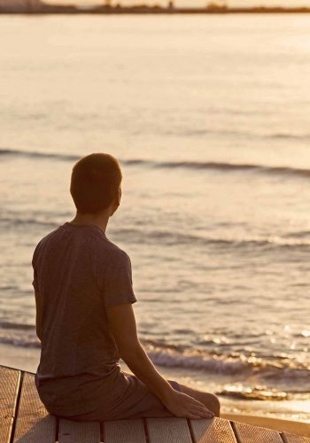 A man sitting quietly overlooking the beach